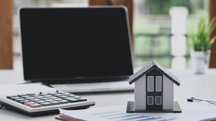 Calculator and model home representing Pennsylvania property tax assessments and appeal calculations
